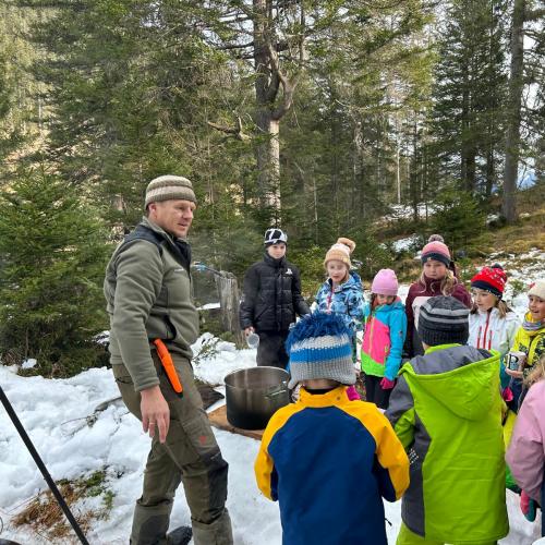 Waldaufseher erklärt Kindern die Tierfütterung